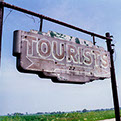 An old sign directing tourists to a destination